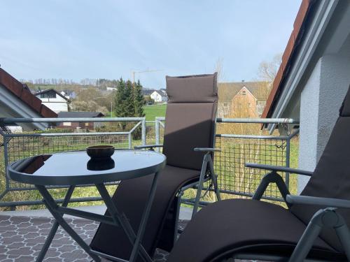 a patio with a table and chairs on a balcony at Ferienwohnung Westerwaldblick Haiger in Haiger