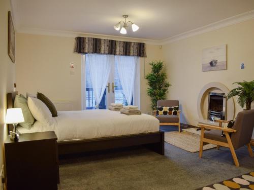 a bedroom with a large bed and a window at March Cottage in Arrochar