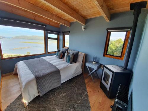 クニスナにあるLagoon Studio - Fantastic Knysna Lagoon views and SOLARのベッドルーム1室(ベッド1台、テレビ付)