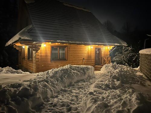 a log cabin covered in snow at night at Drevenice Kaskády Oščadnica Veľká Rača in Oščadnica
