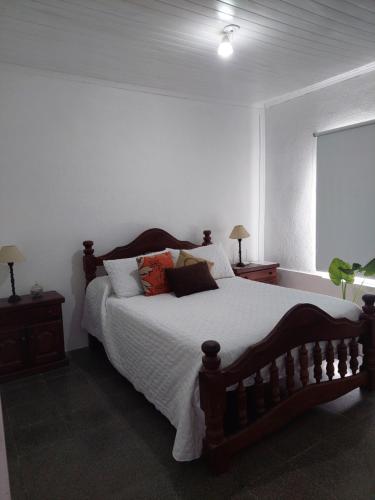 - une chambre avec un grand lit en bois et des oreillers dans l'établissement La casita, à Saladillo