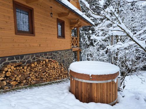 a log cabin in the snow with a fire pit at Drevenice Kaskády Oščadnica Veľká Rača in Oščadnica