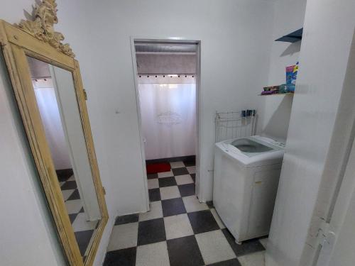 uma casa de banho com um espelho e uma máquina de lavar roupa em La casita em Saladillo