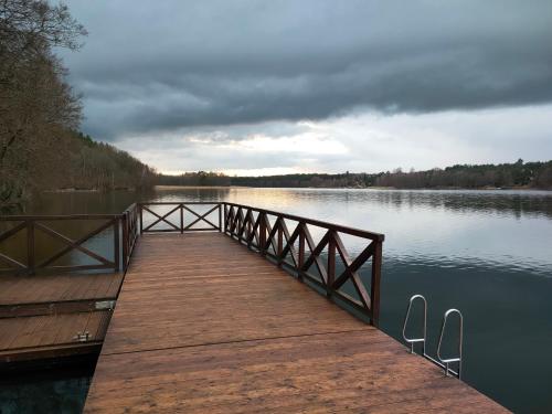 a wooden dock on a lake on a cloudy day at Rozmaryn - Komfortowy domek całoroczny na Kaszubach in Borowy Młyn