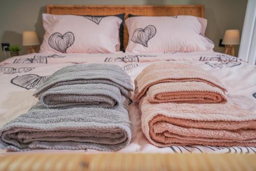 ein Bett mit Kissen und Decken darauf in der Unterkunft Bridge Brazen in Edessa