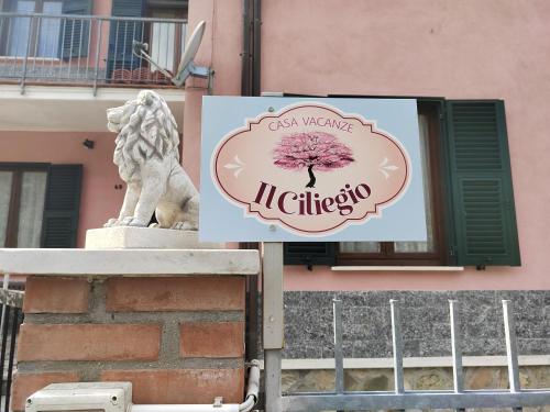 una señal frente a un edificio con una estatua en Il Ciliegio, en Chiama