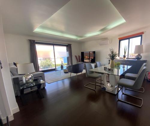 a living room with a table and chairs at Villa Madeira island in Caniço