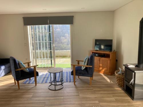 a living room with a table and chairs and a television at Quinta de Varzielas - Agroturismo in Castelo de Paiva
