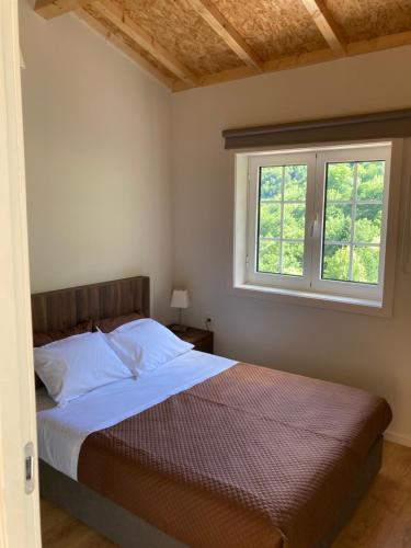 um quarto com uma cama e uma janela em Quinta de Varzielas - Agroturismo em Castelo de Paiva