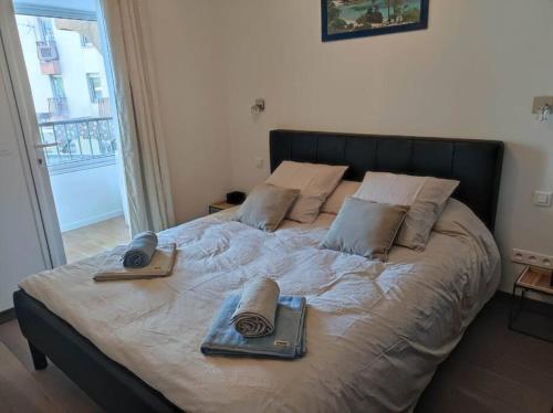a bed with two pillows and two books on it at Appartement sur le port Résidence Marina Palmu in Porto-Vecchio