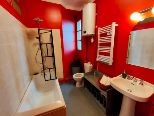 baño con paredes rojas, lavabo y aseo en Au petit châtillonnais, en Châtillon-sur-Seine