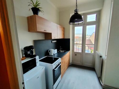 une petite cuisine avec un évier et une cuisinière dans l'établissement Au petit châtillonnais, à Châtillon-sur-Seine