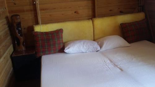 a bed with two pillows on it in a room at Villa Rasta - Ocean View Bungalows in Port Antonio