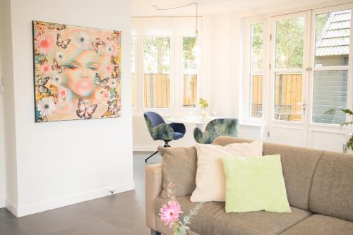 a living room with a couch and a painting at Hotel Villa Ruimzicht in Doetinchem