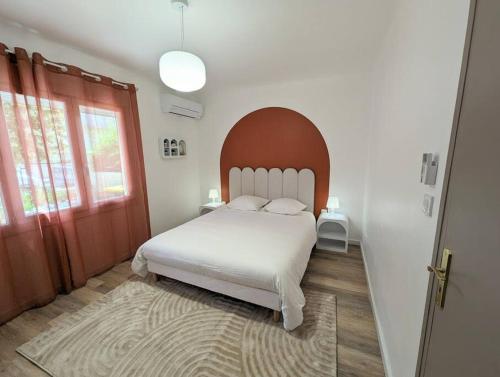 um quarto com uma cama branca e uma grande janela em Le numéro 1 em Perpignan