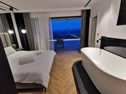Habitación de hotel con bañera, cama y vistas. en Evo Residence Panoramic, en Cluj-Napoca