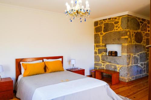 um quarto com uma cama e uma parede de pedra em Casa do Ribeiro em Lago
