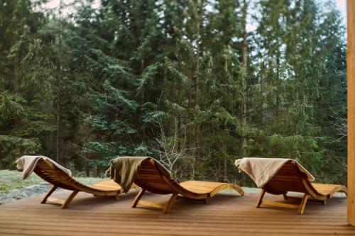 two chairs sitting on a deck with trees in the background at Drevenice Kaskády Oščadnica Veľká Rača in Oščadnica