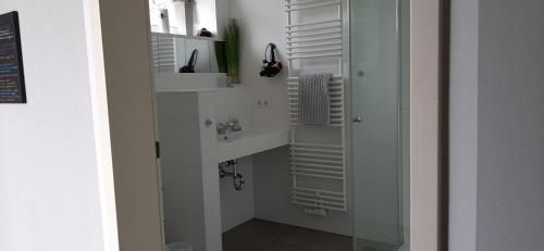 een witte badkamer met een wastafel en een spiegel bij Fewo Relax Family in Borken