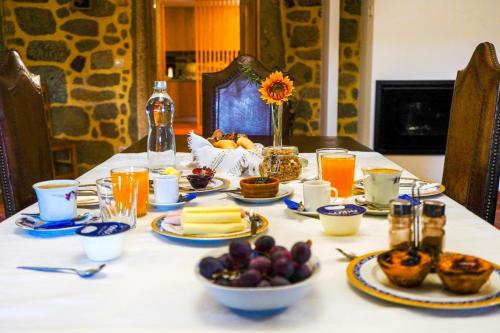 una mesa con platos de comida y fruta. en Casa do Ribeiro en Lago