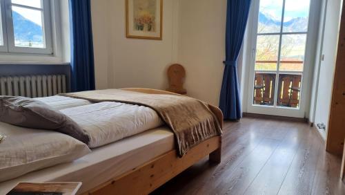 una camera da letto con un letto con tende blu e una finestra di Rochelehof a Marlengo