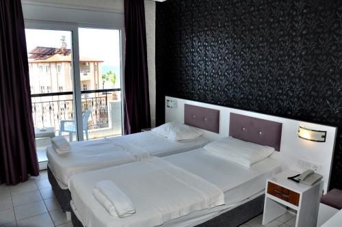 sypialnia z 2 łóżkami i dużym oknem w obiekcie Saygılı Beach Hotel w Side
