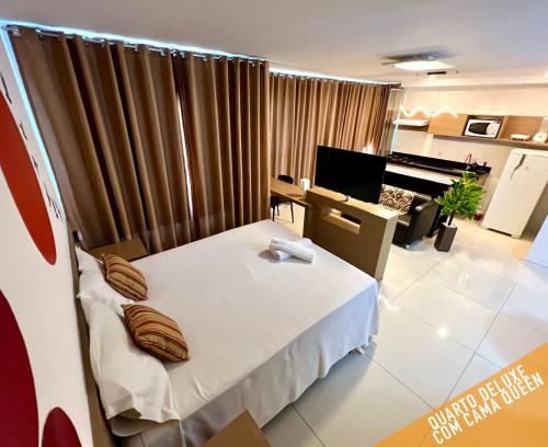 a room with a bed and a desk with a piano at Verano Stay Flat Barra Olímpica in Rio de Janeiro