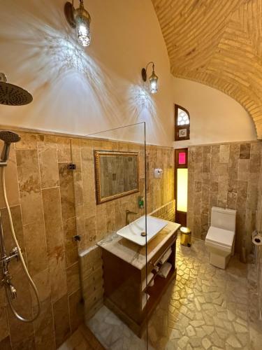 een badkamer met een wastafel, een douche en een toilet bij Marhaba boutique Madrasah 15th-16th century in Bukhara
