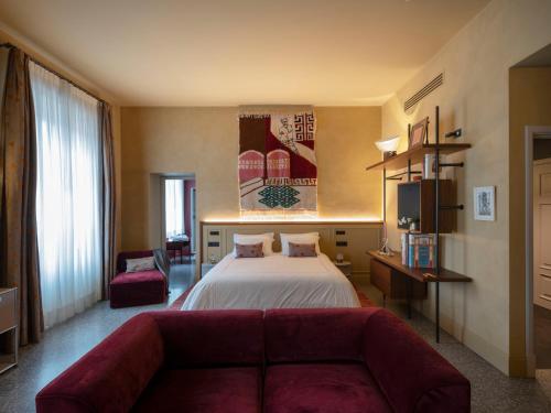 a hotel room with a bed and a couch at Paradis Pietrasanta in Pietrasanta