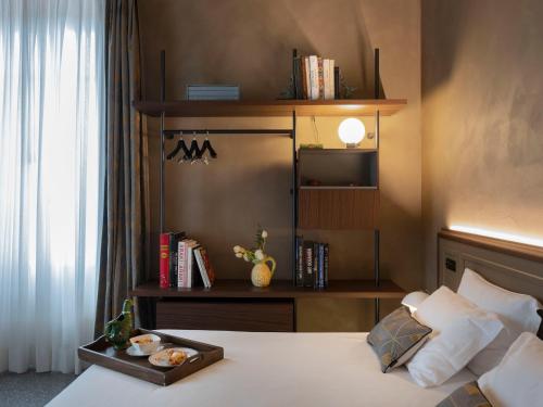 a bedroom with a bed with a tray of food on it at Paradis Pietrasanta in Pietrasanta