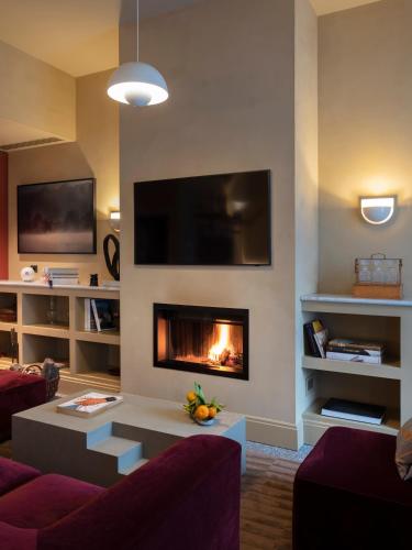 a living room with a fireplace and a tv at Paradis Pietrasanta in Pietrasanta