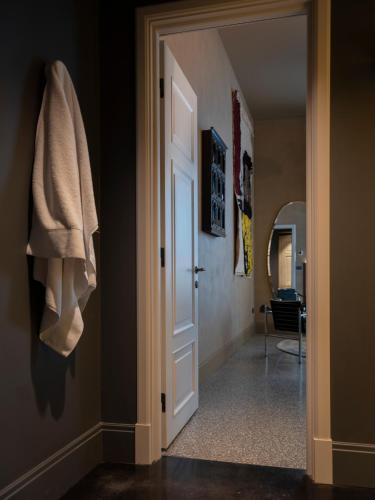 a hallway with a white door and a mirror at Paradis Pietrasanta in Pietrasanta