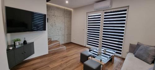 a living room with a couch and a tv at Luxury Apartments Bernardyńska Domek 1 , 2 in Kielce