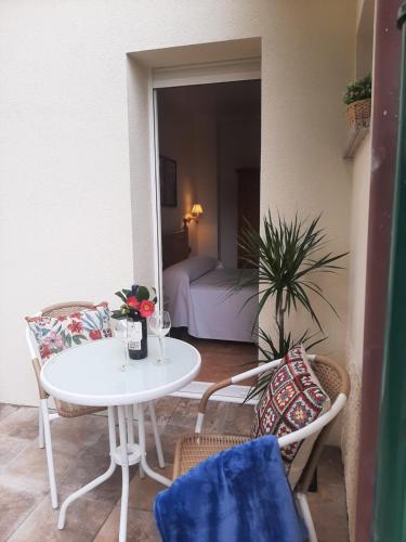 a white table and chairs in a room with a bedroom at Hotel Alvaro frente Palacio-Museo Selgas in Cudillero