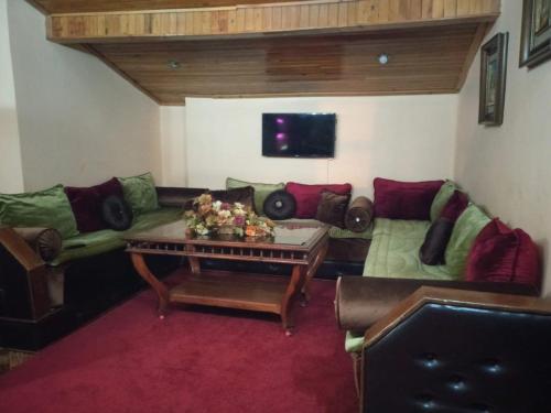 ein Wohnzimmer mit einem Sofa und einem Tisch in der Unterkunft appartement chalet in Imouzzer du Kandar