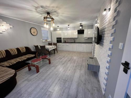a living room with a couch and a kitchen at Apartamenty na Źródlanej in Stężyca
