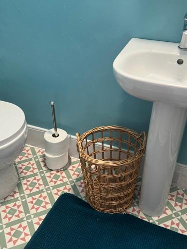 - Baño con lavabo, aseo y cesta en The Shell House en Falmouth