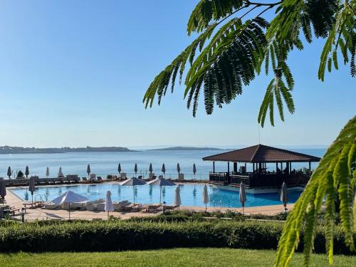 a pool with umbrellas and the ocean in the background at Sozopolis Cliffs Luxury Seaview Villa in Sozopol