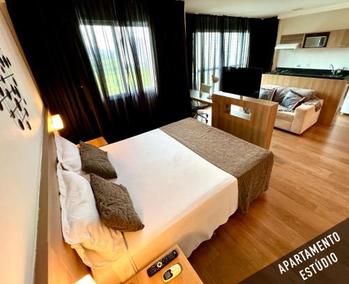 a bedroom with a bed and a living room at Verano Stay Flat Barra Olímpica in Rio de Janeiro