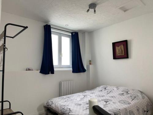 1 dormitorio con 1 cama y una ventana con cortinas azules en Maison CALAIS centre ville L, en Calais