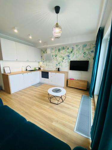 a kitchen with a table in the middle of a room at Apartamenty Białe nad jeziorem Białym in Augustów