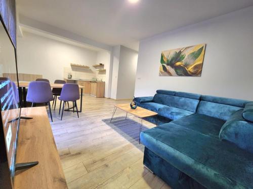 ein Wohnzimmer mit einem blauen Sofa und einem Tisch in der Unterkunft Residence Riverside in Mostar