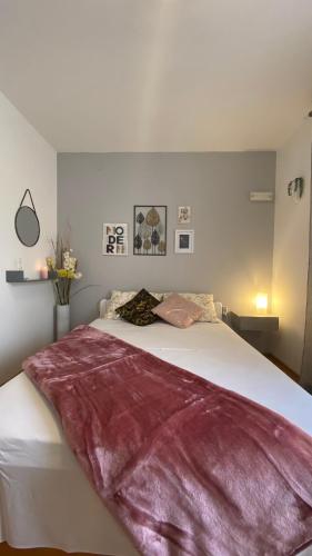 a bedroom with a large bed with a red blanket on it at Guest House Tonica in Krk