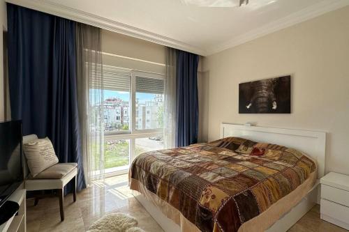 1 dormitorio con 1 cama, 1 silla y 1 ventana en Odyssey Park Penthouse, en Belek