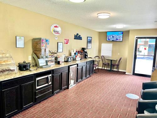 een keuken met een aanrecht en een tafel met stoelen bij Super 8 by Wyndham Columbia/Ft. Jackson SC in Columbia