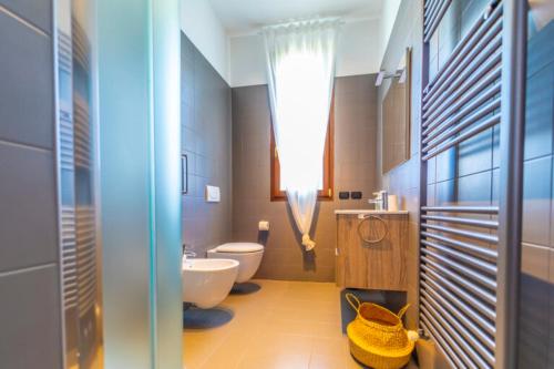 ein Badezimmer mit einem weißen WC und einem Waschbecken in der Unterkunft Casa Schiavoni in Forlì
