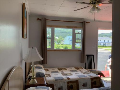 a bedroom with a bed and a window at Hôtel-Motel Rocher Percé in Perce
