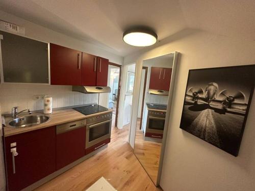 cocina con fregadero y fogones horno superior en Wohnung mit 3 Schlafzimmern, en Gauting