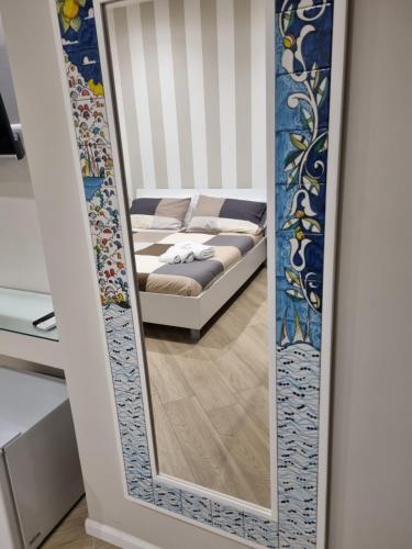a mirror in front of a bed in a room at Cala Di Luna House in Vietri sul Mare