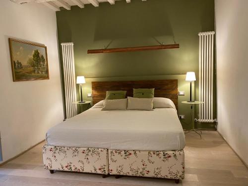 1 dormitorio con 1 cama grande y 2 lámparas en L'ocanda Rancioli, en San Casciano dei Bagni
